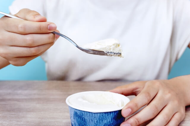 スプーンでアイスを食べる人物